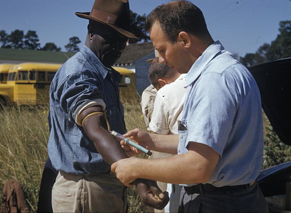 A U.S. Public Health Service worker draws blood from a participant in the Tuskegee study of untreated syphilis, the scandal whose 1972 exposure forced American research ethics into federal law.