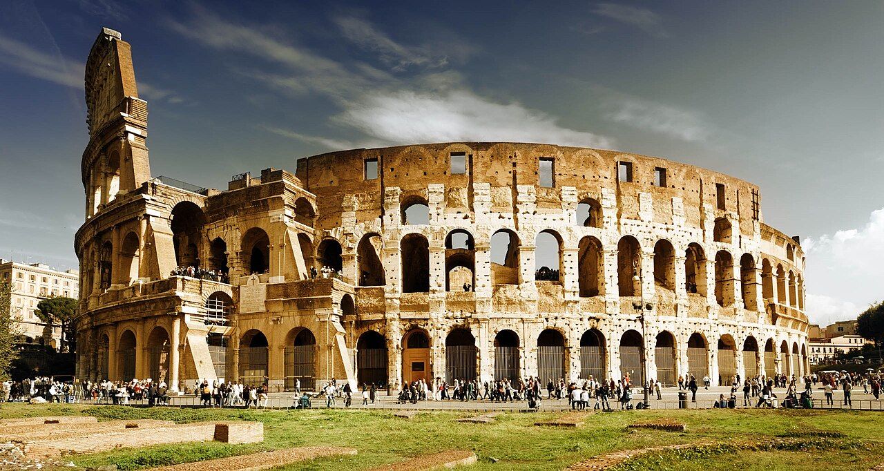 The Colosseum in Rome, a partially ruined four-story elliptical amphitheater of travertine arches