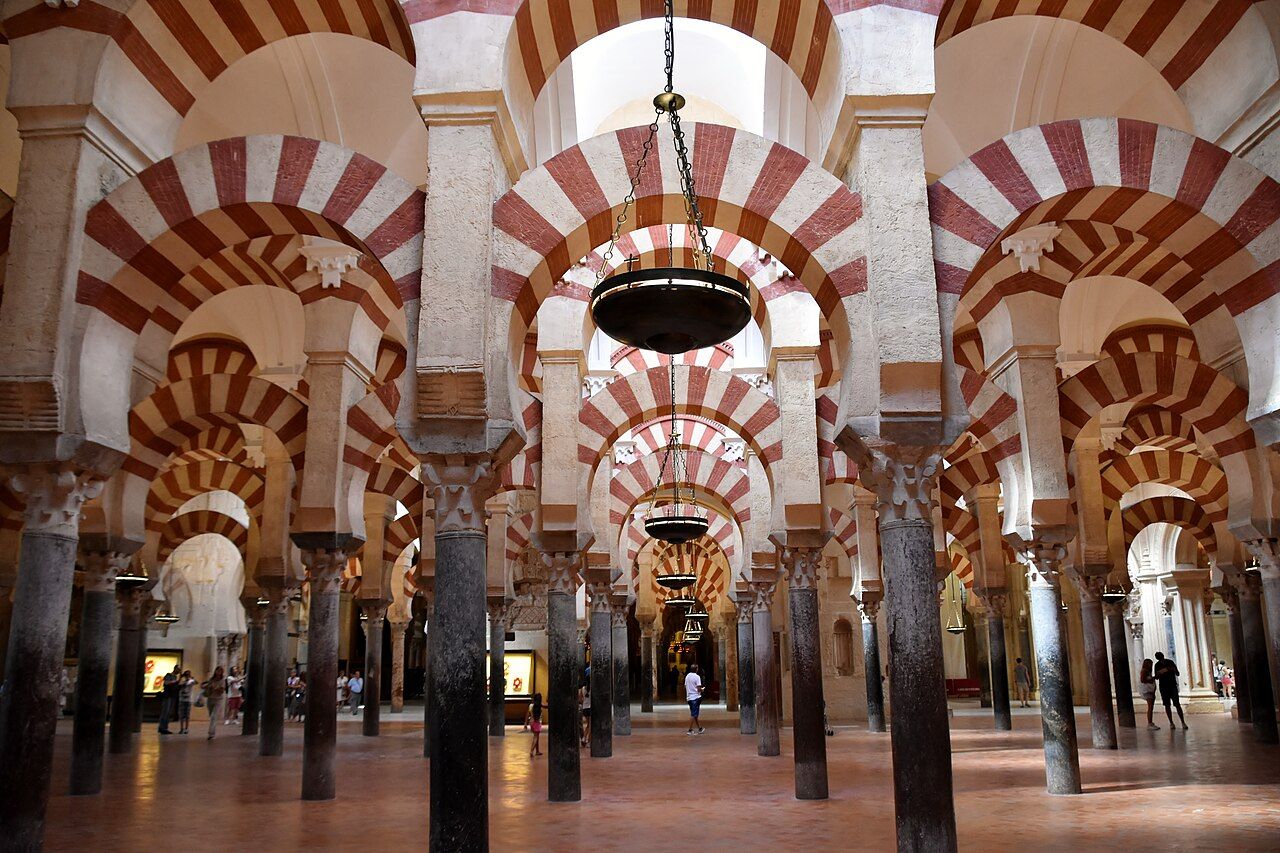 The hypostyle hall of the Great Mosque of Cordoba, begun in 785 and enlarged repeatedly over the next two centuries, reused Roman and Visigothic columns beneath its striped double arches.